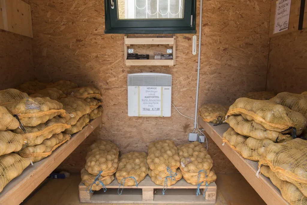 Erdäpfelsäcke auf Paletten im Lagerraum des Hofs